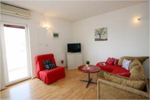 - un salon avec un canapé rouge et deux chaises dans l'établissement Apartments with a parking space Supetar, Brac - 11147, à Supetar