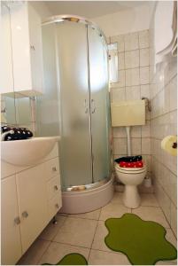 La salle de bains est pourvue d'une douche, de toilettes et d'un lavabo. dans l'établissement Apartments with a parking space Supetar, Brac - 11147, à Supetar