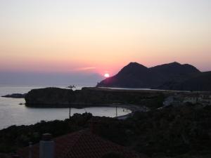 a sunset over the ocean with mountains in the background at Sunset Hotel in Agios Ioannis Kaspaka