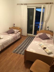 a bedroom with two beds and a window with a view at Apartments with WiFi Pucisca, Brac - 11416 in Pučišća