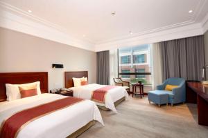 een hotelkamer met 2 bedden en een stoel bij Tongli Lake View Hotel in Suzhou