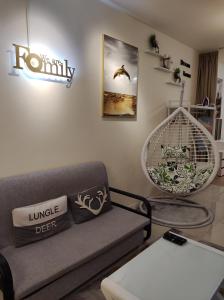 uma sala de estar com um sofá e uma placa na parede em Thirteen Residence [TR06] @ ITCC Manhattan Suites em Kota Kinabalu