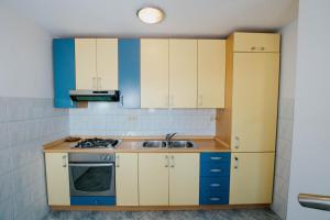 una cocina con armarios azules y blancos y fregadero en Apartments with a parking space Mastrinka, Ciovo - 11283 en Trogir