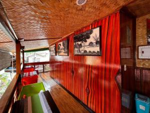 a room with a red wall with a picture on it at Balay Paragua in El Nido