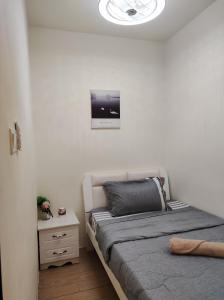 1 dormitorio con 1 cama y reloj en la pared en Thirteen Residence [TR06] @ ITCC Manhattan Suites en Kota Kinabalu