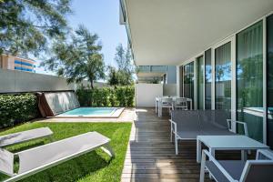 a backyard with a patio furniture and a swimming pool at Luxury Apartment Jesolo in Lido di Jesolo