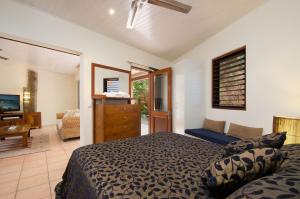 a bedroom with a bed, chair, and a mirror at L'Auberge @ Noosa in Noosa Heads
