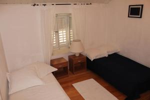 a small bedroom with two beds and a window at Rooms by the sea Makarska - 11096 in Makarska