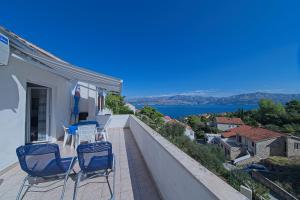 un balcone con sedie e vista sull'acqua di Apartments with parking space Postira, Brac - 11168 a Postira (Postire)