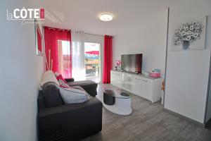 ein Wohnzimmer mit einem Sofa und einem TV in der Unterkunft La Sourcinette T3 sur la côte Bleue Lacote Immo 1 in Carry-le-Rouet