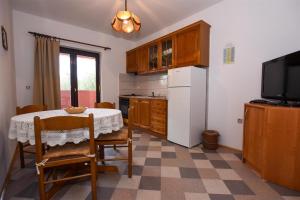 a kitchen with a table and a refrigerator and a tv at Apartments with a parking space Pag - 11358 in Pag