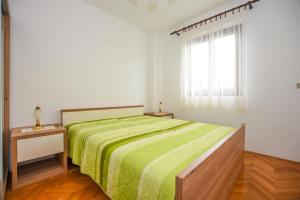 a bedroom with a green bed and a window at Apartments with a parking space Pag - 11358 in Pag