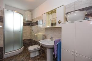 a bathroom with a toilet and a sink and a shower at Apartments with a parking space Pag - 11358 in Pag