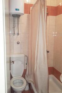 a bathroom with a toilet and a shower curtain at Apartment Gradac 11332a in Gradac