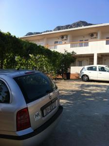 a car parked in a parking lot in front of a building at Apartments with a parking space Gradac, Makarska - 11332 in Gradac