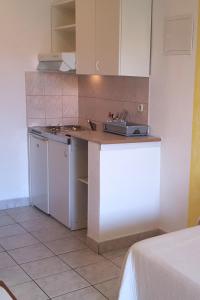 eine Küche mit einer Theke mit einer Spüle und einem Herd in der Unterkunft Apartments with a parking space Gradac, Makarska - 11332 in Gradac