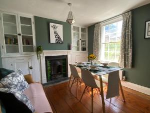 a living room with a table and a fireplace at Charming Cottage mins from Chichester City Centre in Chichester