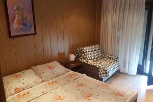 a hotel room with a bed and a chair at Apartments for families with children Lopar, Rab - 10402 in Lopar