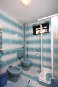 a blue bathroom with a toilet and a shower at Apartments for families with children Lopar, Rab - 10402 in Lopar