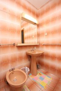 a bathroom with a sink and a mirror at Apartments for families with children Lopar, Rab - 10402 in Lopar