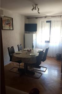 a dining table and chairs in a living room at Apartments for families with children Lopar, Rab - 10402 in Lopar