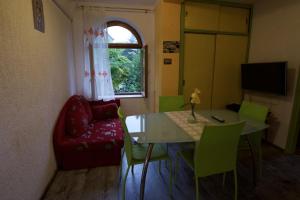 a living room with a table and a red chair at Apartments and rooms with parking space Lovran, Opatija - 10403 in Lovran