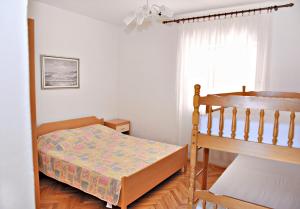 a small bedroom with a bed and a window at Apartments by the sea Metajna, Pag - 10405 in Zubovići
