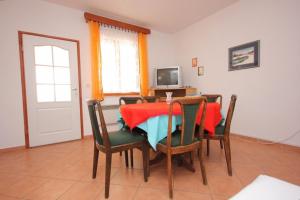 una sala da pranzo con tavolo, sedie e televisione di Holiday house with a parking space Kraj, Pasman - 8258 a Tkon (Tuconio)