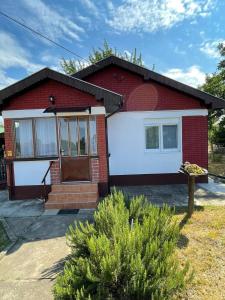uma casa vermelha e branca com uma porta da frente em Kuća za odmor Fjaka em Sotin