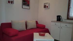 a living room with a red couch and a table at Apartment Gradac 11332d in Gradac
