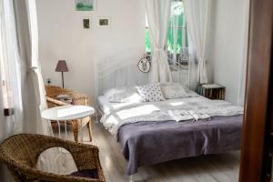 a bedroom with a bed and a table and a chair at Apartamenty Stacja Kasina in Kasina Wielka