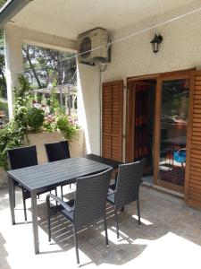 a black table and chairs on a patio at Apartments by the sea Cove Blaca, Mljet - 10416 in Maranovići