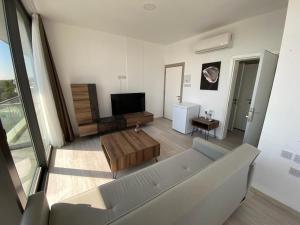 a living room with a couch and a flat screen tv at Alya Rooms in North Nicosia