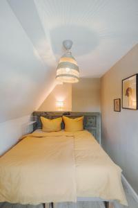 ein Schlafzimmer mit einem großen Bett mit gelben Kissen in der Unterkunft Stadthytte Ferienhaus in Rostock