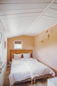 a bedroom with a large bed with white sheets at Stadthytte Ferienhaus in Rostock