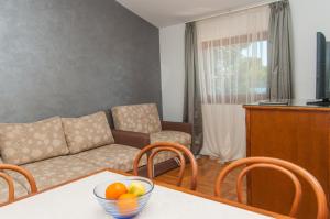 sala de estar con sofá y mesa con un bol de fruta en Apartment Mali Losinj 10420b en Mali Lošinj