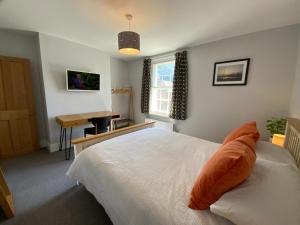 a bedroom with a bed and a desk and a window at Charming Cottage mins from Chichester City Centre in Chichester