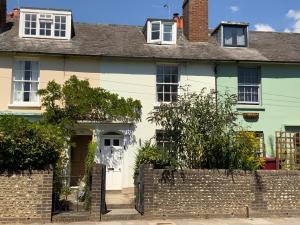 a white house with a brick fence in front of it at Charming Cottage mins from Chichester City Centre in Chichester