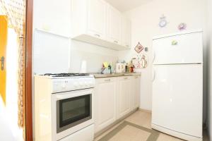 グラダツにあるApartments with a parking space Gradac, Makarska - 6825の白いキッチン(コンロ、冷蔵庫付)