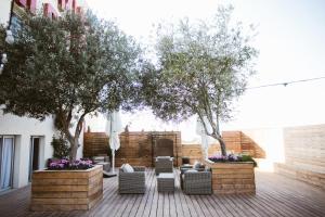 un patio con árboles y sofás, árboles y flores en ADVA Boutique מלון אדווה, en Bet Yannay
