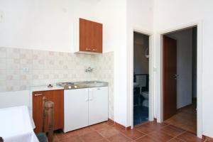 a kitchen with a sink and a toilet in a room at Apartment Pomena 10426b in Goveđari