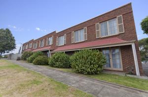 un edificio di mattoni con cespugli di fronte di William Dutton Motel a Portland