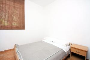 Bett in einem weißen Zimmer mit einem Holztisch in der Unterkunft Apartments by the sea Pomena, Mljet - 10426 in Goveđari