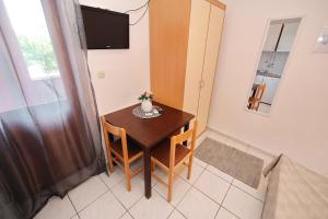 a small dining room table with two chairs and a television at Apartments by the sea Tkon, Pasman - 8414 in Tkon