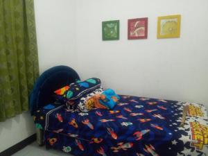 a bedroom with a bed with a blue comforter at Argolawu Homestay in Tawangmangu
