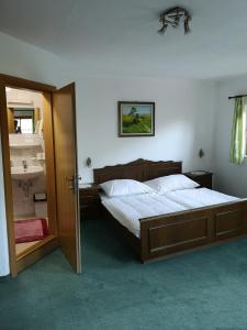 a bedroom with a large bed and a bathroom at Pension Schlager Taxerhof in Bad Hofgastein