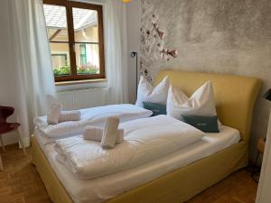 1 dormitorio con 2 camas con sábanas blancas y ventana en Mariandls Appartement&Mehr, en Spitz