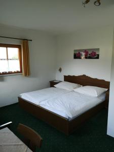 a bedroom with a bed with white sheets and a window at Pension Schlager Taxerhof in Bad Hofgastein +4 photos