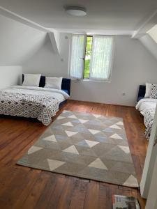 a living room with two beds and a rug at Kucica Djukanovic Dobri Potok in Krupanj