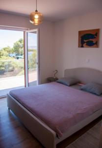 um quarto com uma cama grande e uma porta de vidro deslizante em Vila Casa di mare Jelsa, otok Hvar em Jelsa